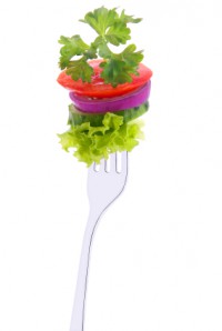 lettuce, cucumber, onion, tomato and parsley on a fork isolated